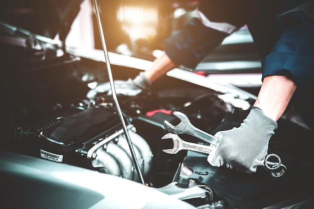 Técnico de mano de primer plano sosteniendo la llave para reparar el coche