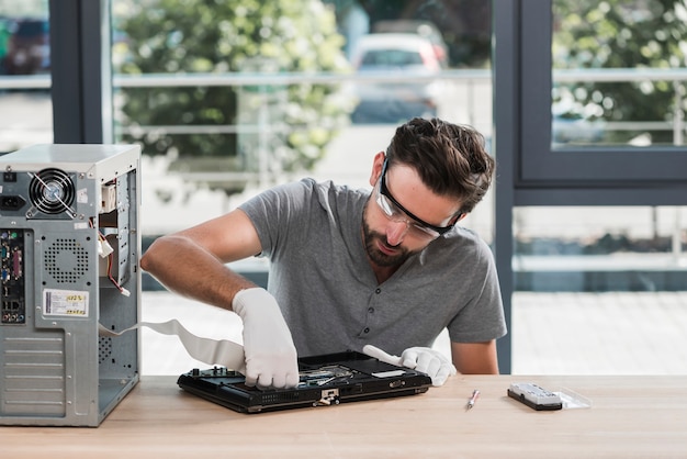 Técnico masculino que fija la computadora en taller