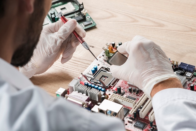 Técnico masculino trabalhando na placa-mãe do computador