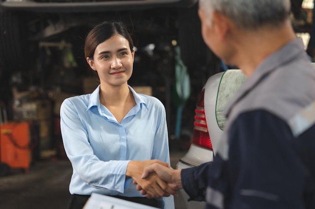 Foto técnico mecânico fazendo acordo de aperto de mão com cliente comercial na ocupação de oficina de serviço de garagem de automóveis para reparação de manutenção de automóveis trabalhador da indústria adulta saudação para acordo com o cliente