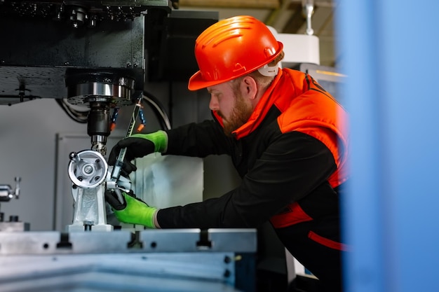 Técnico mecánico operativo del centro de máquinas cortadoras de fresado cnc en el taller de herramientas