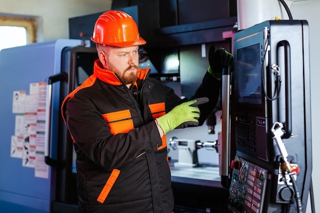 Técnico mecánico operativo del centro de máquinas cortadoras de fresado cnc en el taller de herramientas