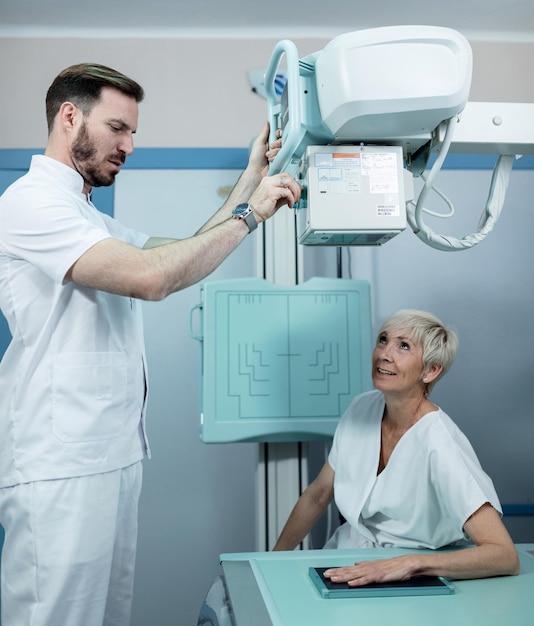 Foto técnico médico preparando um paciente para raio-x de mão na clínica