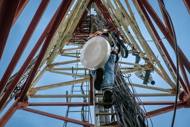 Técnico não reconhecido escalando uma torre de telecomunicações