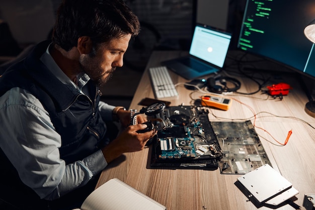 Foto técnico noturno e trabalhando em horas extras de reparo da placa-mãe e fabricando um dispositivo eletrônico em uma oficina ou loja pessoa homem e cara consertando hardware de um computador para tecnologia em um laboratório