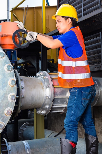 Técnico o ingeniero que trabaja en una válvula en la construcción de equipos técnicos o instalaciones industriales en una fábrica o servicio público.