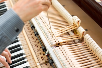 Técnico de piano profesional que repara el mecanismo de martillo con vástago. reparador tratando de afinar y restaurar instrumentos musicales antiguos. | Foto Premium