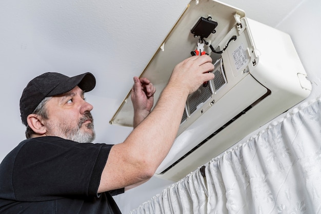 Foto técnico profesional en climatización cambiando el mando wifi de una unidad interna de un split.