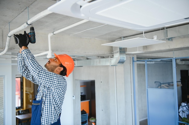 Foto técnico profesional que mantiene el aire acondicionado moderno en interiores espacio para texto