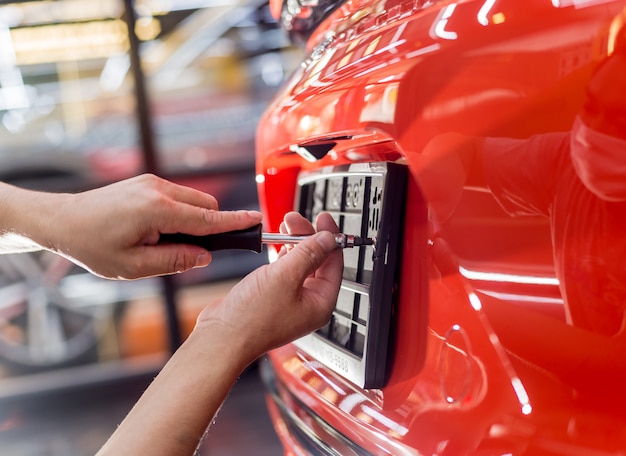 Técnico que cambia el número de placa del coche en el centro de servicio.