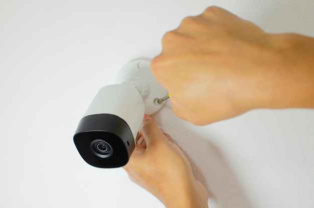 Técnico que instala o sistema de segurança da câmera CCTV videocam CCTV Câmera de segurança CFTV câmera branca.