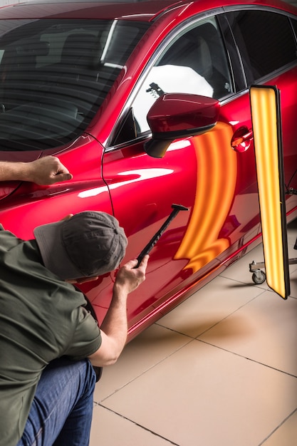 Foto el técnico quita abolladuras del coche de cerca