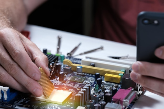 Foto un técnico repara una placa base en un centro de servicio reparación de computadoras