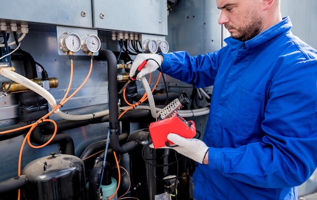 El técnico repara los sensores de temperatura electrónicos con un soldador electrónico.