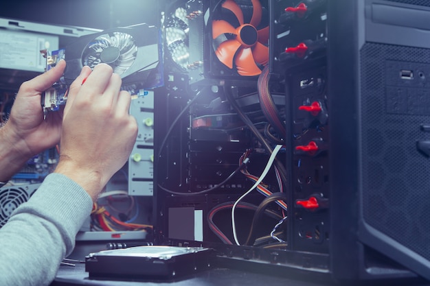 Foto técnico de reparación de una computadora, el proceso de sustitución de componentes en la placa base.