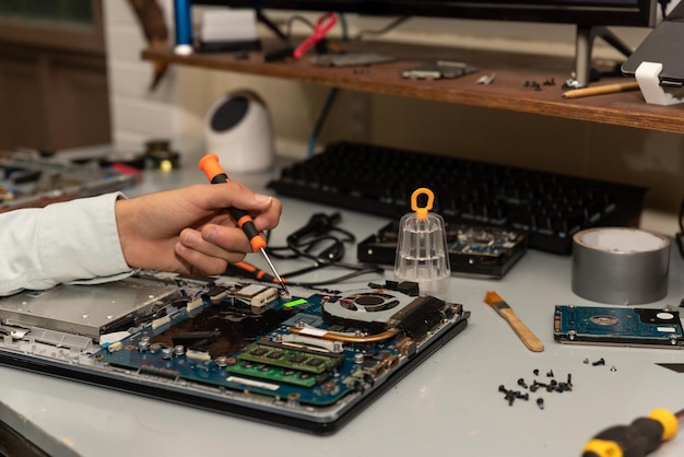 Técnico de reparación de computadoras reparando una computadora portátil