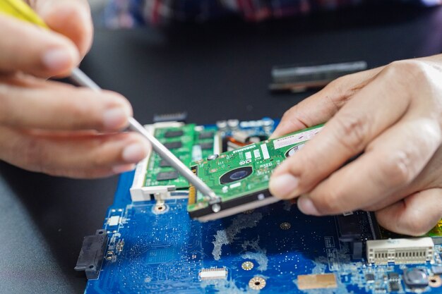 Foto técnico de reparación en el interior de la computadora del disco duro.