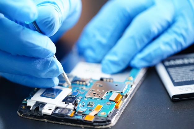 Técnico de reparación de microcircuito placa principal del teléfono inteligente.