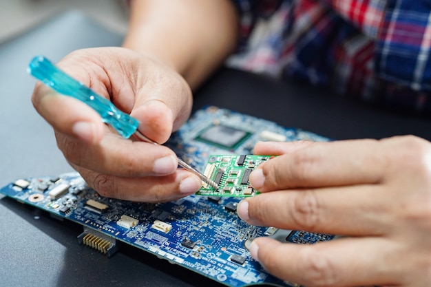 Técnico en reparación de microcircuitos placa principal de la computadora.