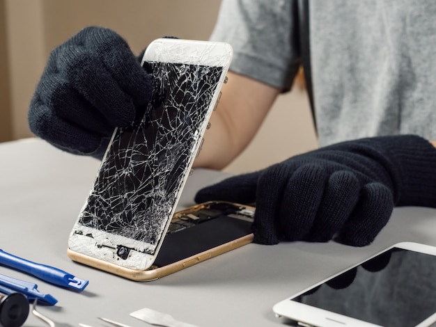 Foto técnico de reparación de teléfono inteligente roto en el escritorio