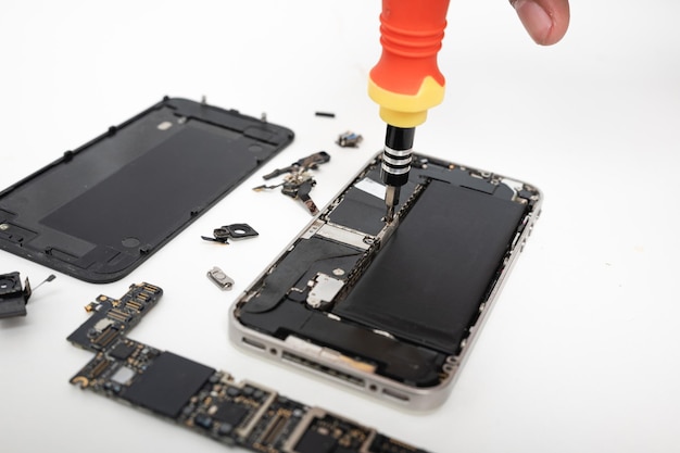 Técnico reparando dentro da placa-mãe do smartphone com ferramentas para recuperação