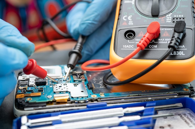 Técnico reparando dentro do telefone celular por circuito integrado de ferro de solda o conceito de tecnologia de hardware de dados