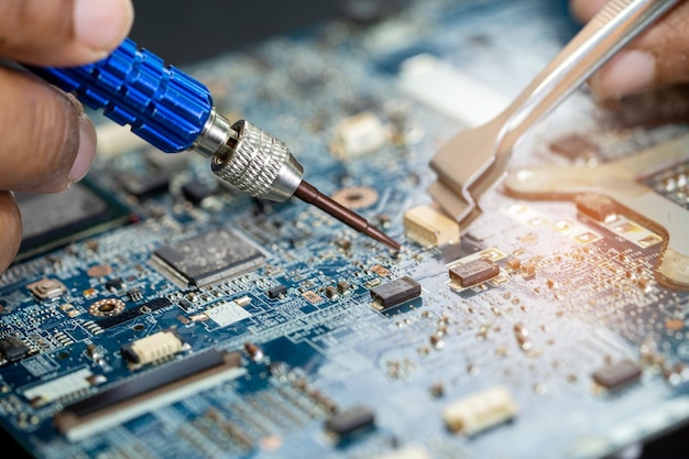 Técnico reparando el interior de la placa de circuito impreso PCB mediante soldador Circuito integrado el concepto de técnico y tecnología de hardware de datos