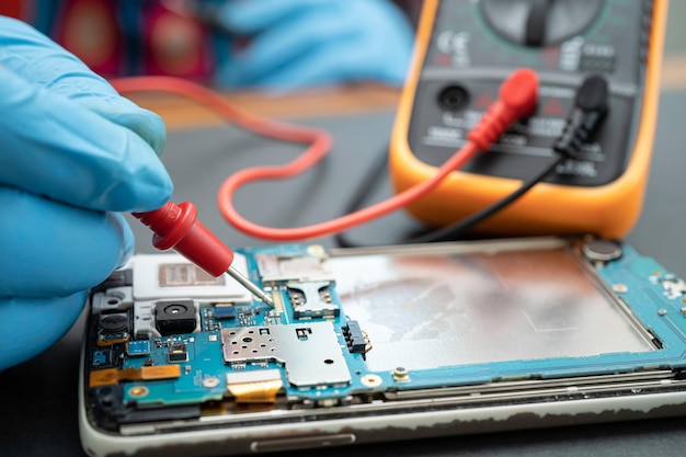 Técnico reparando el interior del teléfono móvil mediante soldador. Circuito integrado. el concepto de datos, hardware, tecnología.