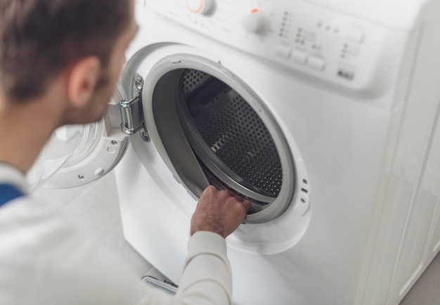 Técnico revisando una lavadora en casa