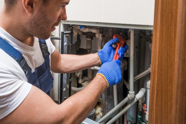 Foto técnico sanitário que trabalha com tubos