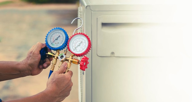 Foto técnico de servicio de aire acondicionado hvac que utiliza medidores para comprobar el refrigerante y añadir refrigerante