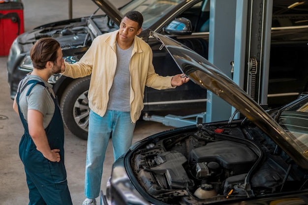 Técnico en servicio de automóviles hablando con el cliente.