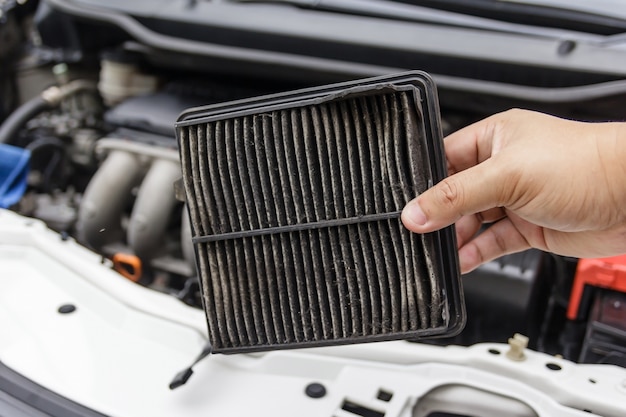 Técnico sosteniendo filtro de aire sucio para coche