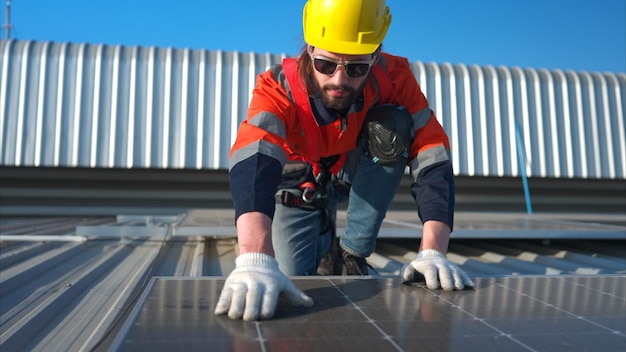 Técnico trabajando en el panel solar en el techo del almacén para inspeccionar los paneles solares
