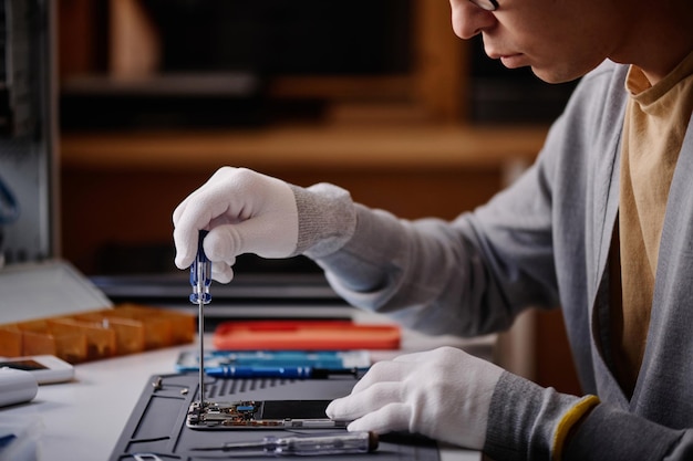 Técnico trabajando en la reparación de teléfonos móviles en el taller