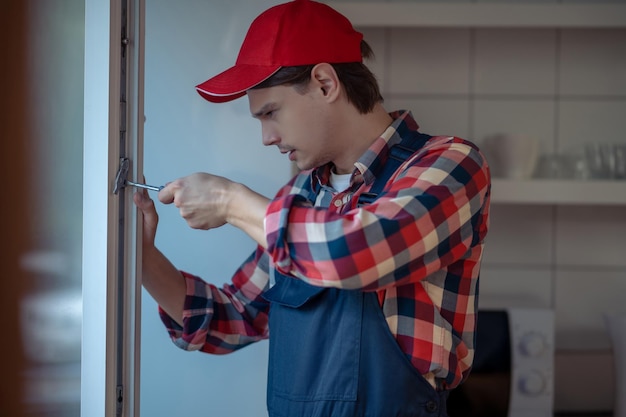 Un técnico tranquilo que instala el mecanismo de bloqueo de la ventana