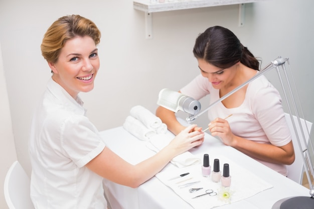 Técnico de uñas dando al cliente una manicura