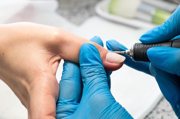 Técnico de uñas dando a un cliente una manicura.