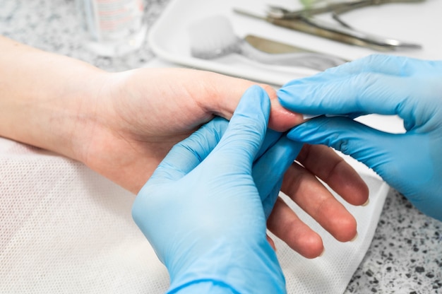 Técnico de uñas dando a un cliente una manicura.