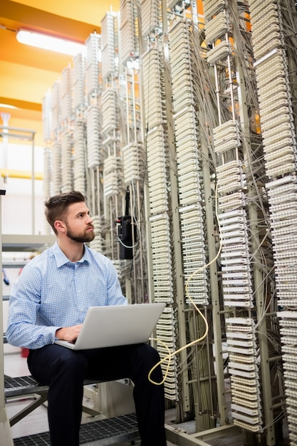 Técnico usando laptop enquanto analisa o servidor