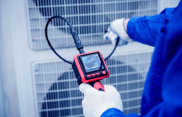 El técnico utiliza una cámara digital para comprobar la obstrucción del intercambiador de calor.