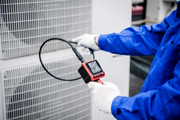 El técnico utiliza una cámara digital para comprobar la obstrucción del intercambiador de calor.