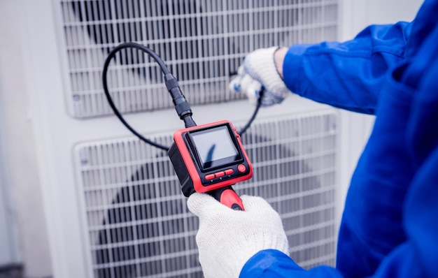 El técnico utiliza una cámara digital para comprobar la obstrucción del intercambiador de calor.