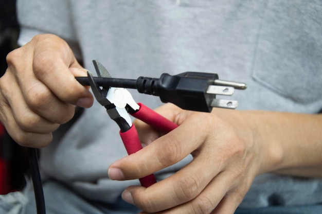 El técnico utiliza pinzas de mano roja para cortar cables herramientas mecánicas