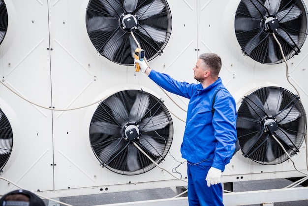 El técnico utiliza un termómetro infrarrojo de imágenes térmicas para comprobar el intercambiador de calor de la unidad de condensación