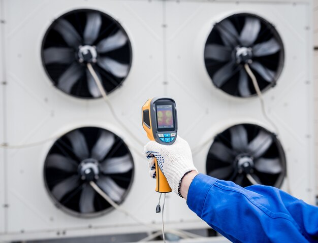 El técnico utiliza un termómetro infrarrojo de imágenes térmicas para comprobar el intercambiador de calor de la unidad de condensación