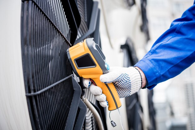 El técnico utiliza un termómetro infrarrojo de imágenes térmicas para comprobar el intercambiador de calor de la unidad de condensación