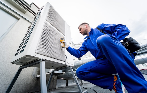 El técnico utiliza un termómetro infrarrojo de imágenes térmicas para comprobar el intercambiador de calor de la unidad de condensación