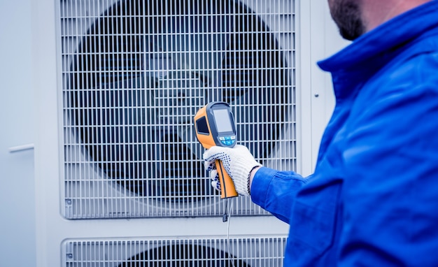 El técnico utiliza un termómetro infrarrojo de imágenes térmicas para comprobar el intercambiador de calor de la unidad de condensación