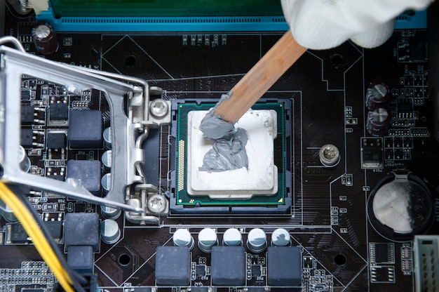 Técnico de vista superior que aplica refrigeración de silicona en chips de CPU